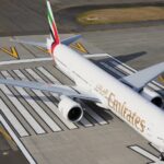 An aerial view of the Emirates Boeing 777 being parked on a runway.