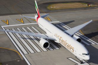 An aerial view of the Emirates Boeing 777 being parked on a runway.