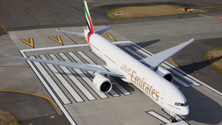 An aerial view of the Emirates Boeing 777 being parked on a runway.