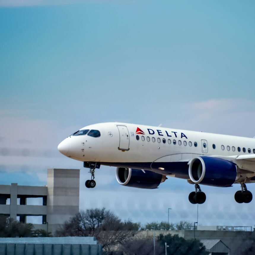 A large white passenger plane in flight in a blue sky