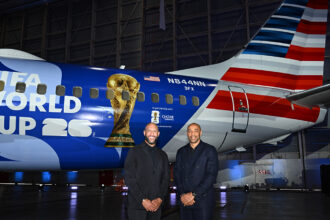 Tim Howard and Thierry Henry pose in front of American Airlines' FIFA World Cup 26-themed aircraft livery