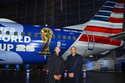 Tim Howard and Thierry Henry pose in front of American Airlines' FIFA World Cup 26-themed aircraft livery