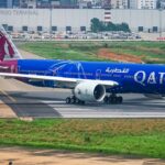 A blue and red Qatar Airways aircraft gets ready for takeoff