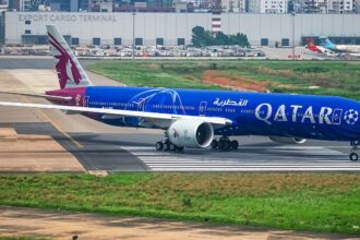 A blue and red Qatar Airways aircraft gets ready for takeoff