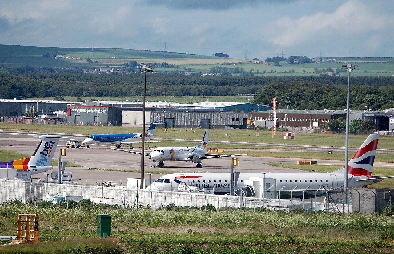 Aberdeen Airport. Commercial aircraft are parked and taxiing on the runway at an airport, including planes from British Airways.