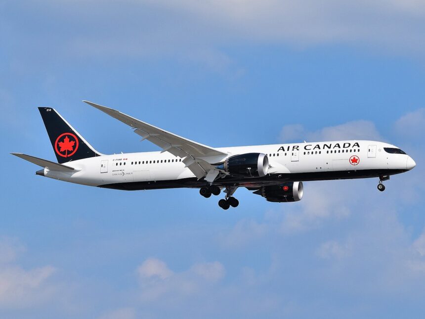 Air Canada Boeing 787 Dreamliner approaching Newark Liberty International Airport under a blue sky.