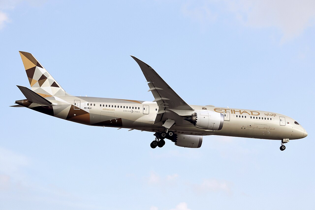 Etihad Airways B787 landing at Toronto Pearson International Airport, in front of a blue sky. Low-angle shot of the plane with the landing gear out.