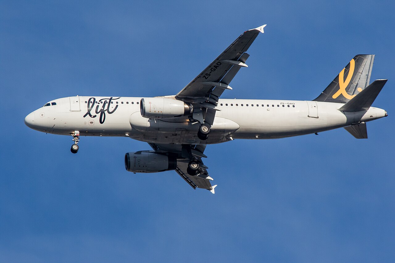 Lift aircraft ZS-GAO A320-231 arriving at CPT, flying through a blue sky. White, black and yellow livery.