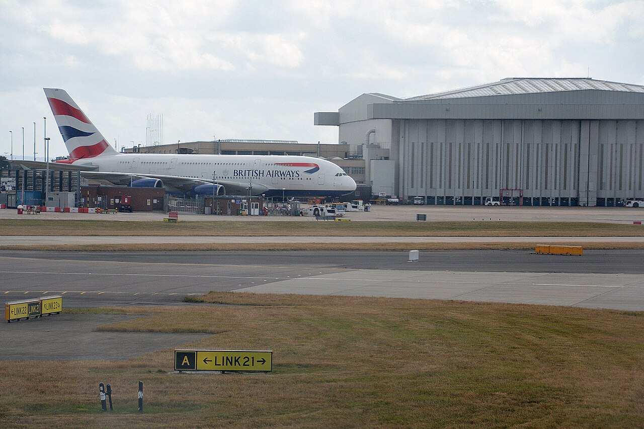 British Airways aircraft at London Heathrow Airport. The sky is grey, the aircraft is on the ground. 