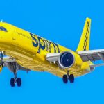 Spirit Airlines A321 flying under a blue sky. Yellow livery.