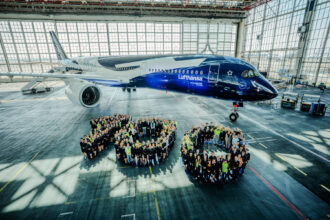 Over 200 Lufthansa employees positioned in front of an Airbus A350, arranged to create the number 100