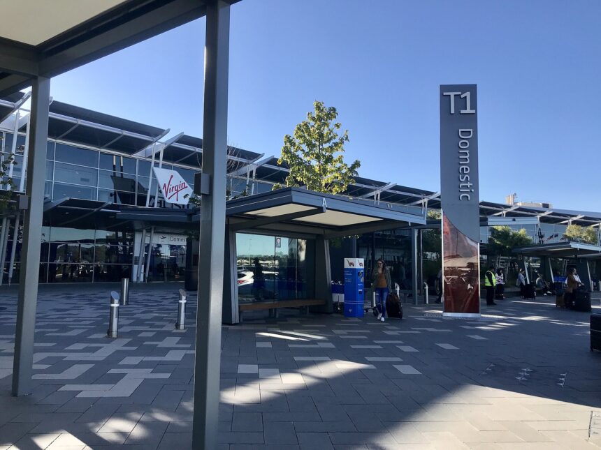 The entrance of Terminal One at Perth Airport, taken in 2022. It is a bright day with blue sky in the background.