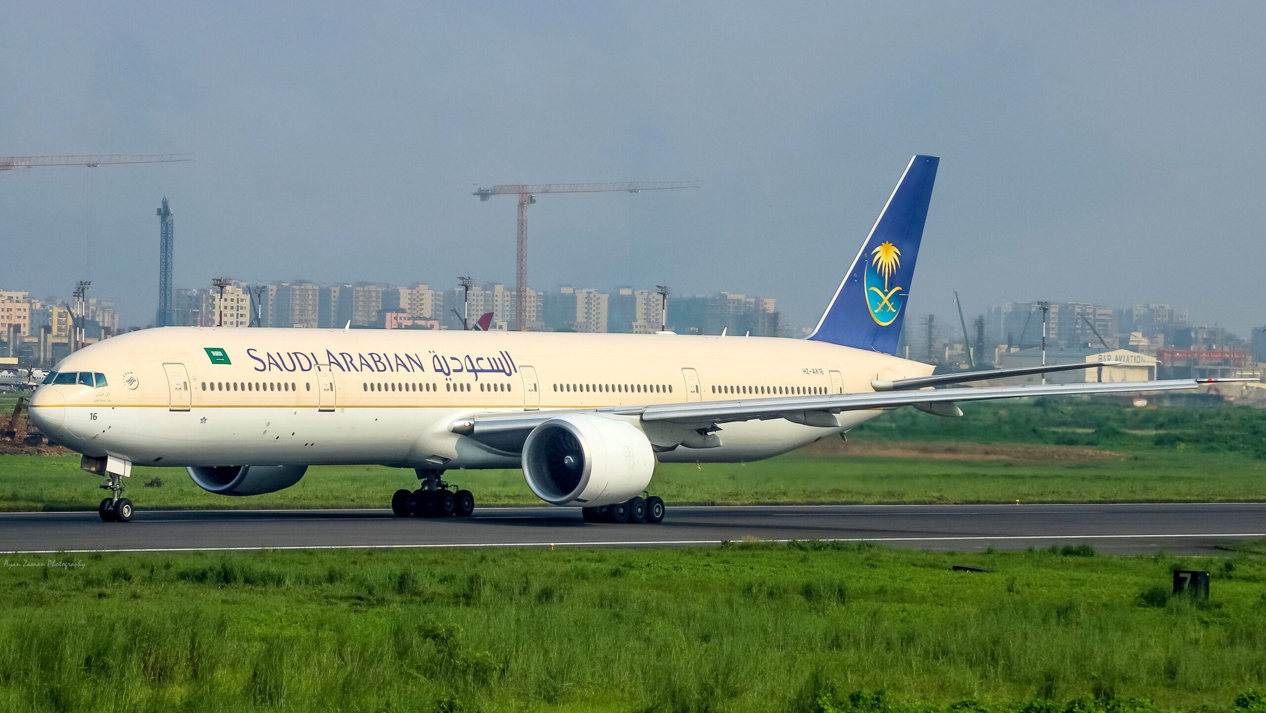 White and Blue Saudia Boeing 777 on the runway on a clear day