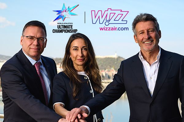Two men, one woman with their hands in together in front of them, "Wizz Air" and "Ultimate Championship" written behind them.