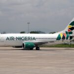 An Air Nigeria Boeing 737-300 aircraft captured on the airport tarmac, featuring its Air Nigeria branding and signature colorful tail.