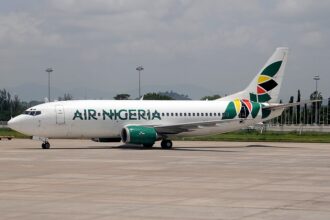 An Air Nigeria Boeing 737-300 aircraft captured on the airport tarmac, featuring its Air Nigeria branding and signature colorful tail.