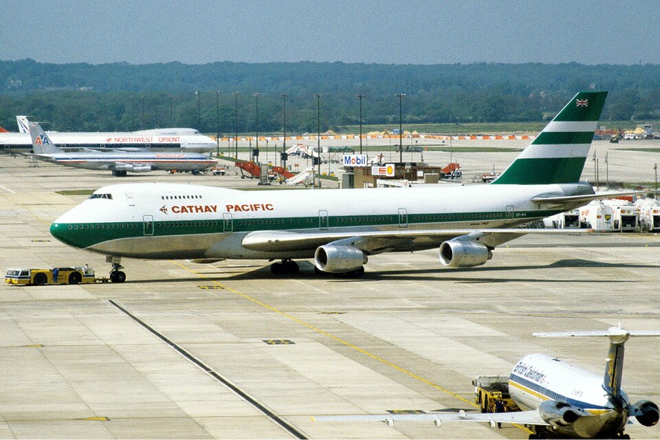 A photograph of a Cathay Pacific Boeing 747-200 (registration VR-HIA) on the tarmac at London Gatwick Airport.