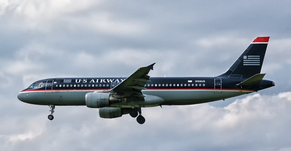 Close-up of US Airways Airbus A320-214 aircraft nose and cockpit with airline livery visible.