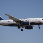 U.S. Airways Airbus A319 flying through the blue sky. Blue, red and white livery.