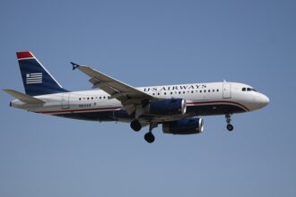 U.S. Airways Airbus A319 flying through the blue sky. Blue, red and white livery.