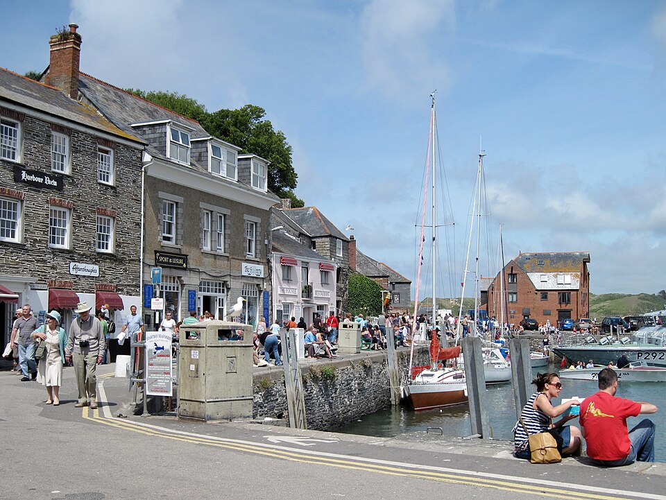 Coastal harbour scene with small fishing boats moored in calm green water.