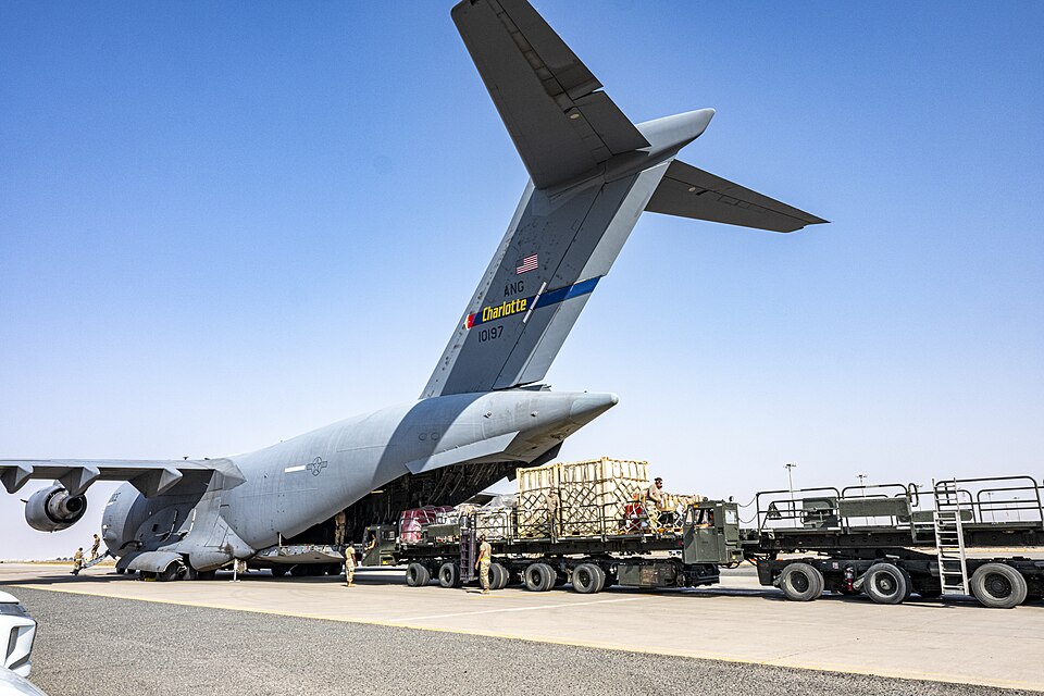 U.S. Air Force load humanitarian aid cargo aboard a C-17 Gobblemaster in 2025.