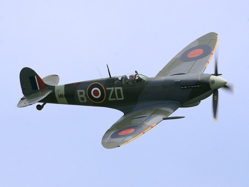 A high-angle shot of the Supermarine Spitfire MH434 in flight against a clear sky.