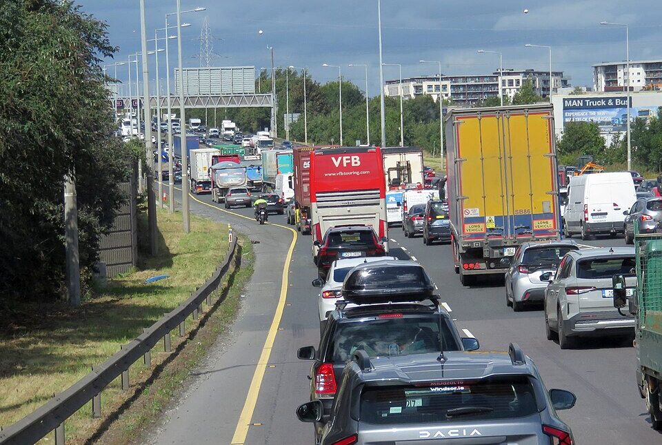 A high-angle view of a multi-lane motorway in Ireland experiencing heavy traffic congestion.
