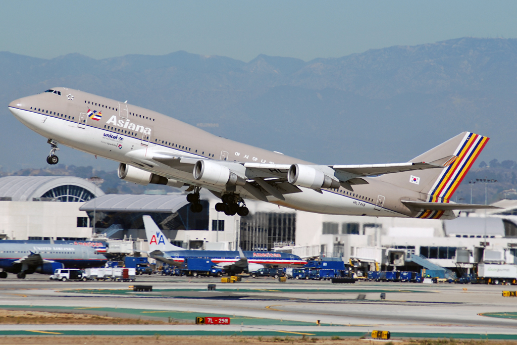 Asiana Airlines B747 departing Los Angeles International Airport (LAX). Grey and white livery with yellow, white, red and blue stripes on the tail.