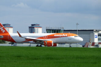 EasyJet aircraft after landing at Glasgow Airport behind grass and under a grey sky