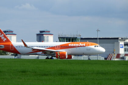 EasyJet aircraft after landing at Glasgow Airport behind grass and under a grey sky