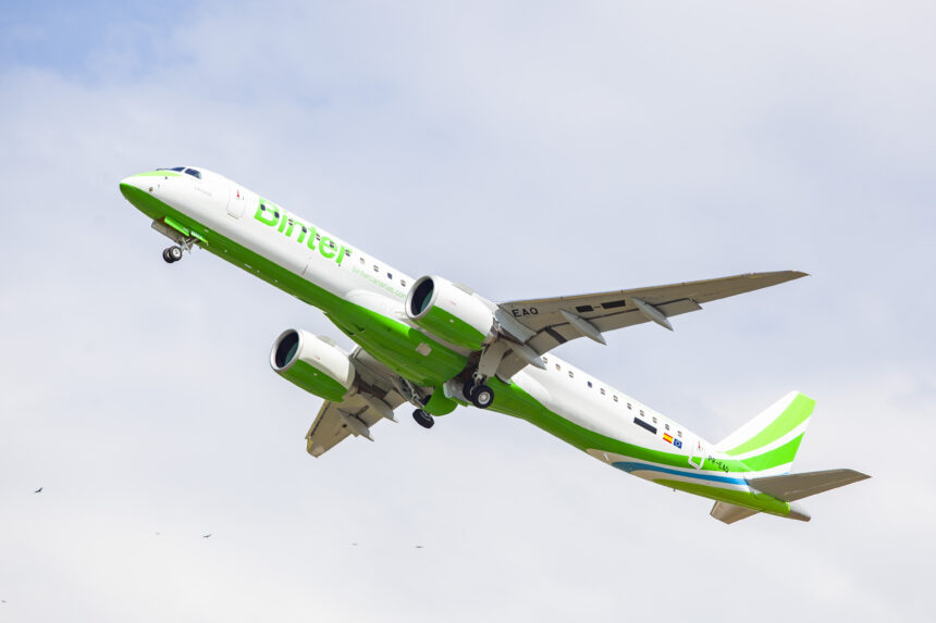 A green and white Binter Canarias plane soaring into the sky.