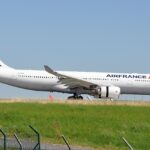 Air France aircraft between green grass and clear blue skies, on the ground.