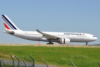 Air France aircraft between green grass and clear blue skies, on the ground.
