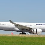 Air France aircraft between green grass and clear blue skies, on the ground.