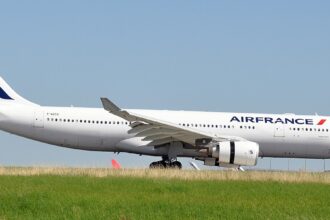 Air France aircraft between green grass and clear blue skies, on the ground.