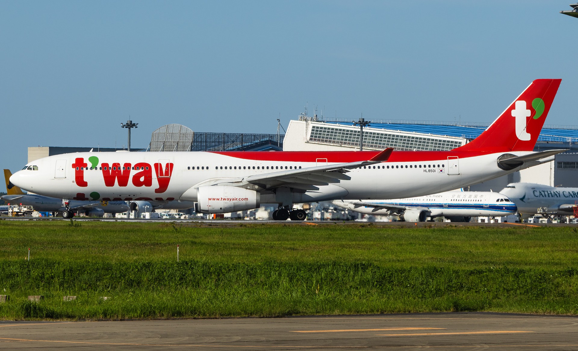 t'way Air A330ceo at an airport taxiway in the backdrop of a china southern airline aircraft and a Cathay Pacific Boeing 747