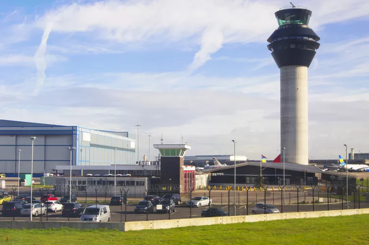 Manchester Airport, with blue but cloudy skies and grass surrounding the built up area.
