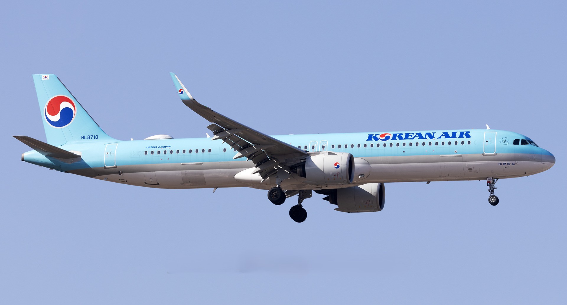 A Korean Air A321 aircraft with its old livery on approach indicated with its landing gear extended.