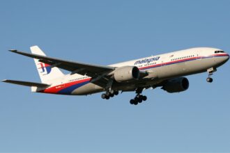 Malaysia Airlines Boeing 777 flying through the blue sky