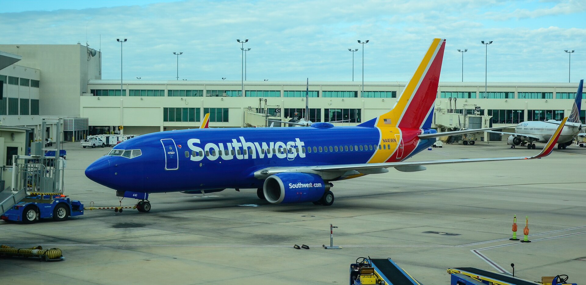 Southwest Airlines aircraft parked at Florida Airport, blue sky and buildings in the background.