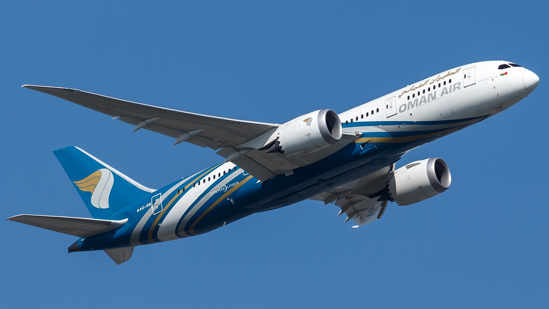 Oman Air aircraft amid blue skies, flying over the image being taken.