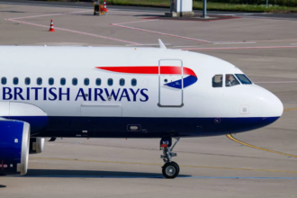 A large white British Airways jetliner waiting on the tarmac at an airport
