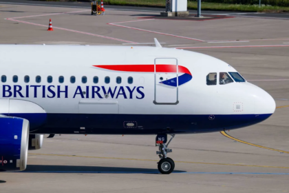A large white British Airways jetliner waiting on the tarmac at an airport