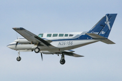 A small blue and white plane flying in a clear skty