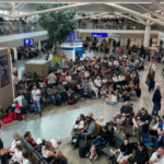 A busy airport waiting area filled with people sitting down