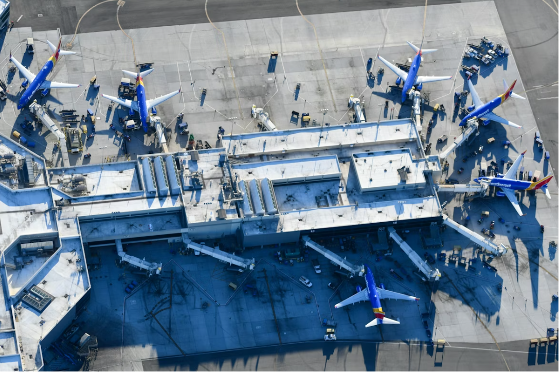 An aerial view of an airport with several blue and white planes