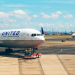 A large white United jetliner sitting at the airport