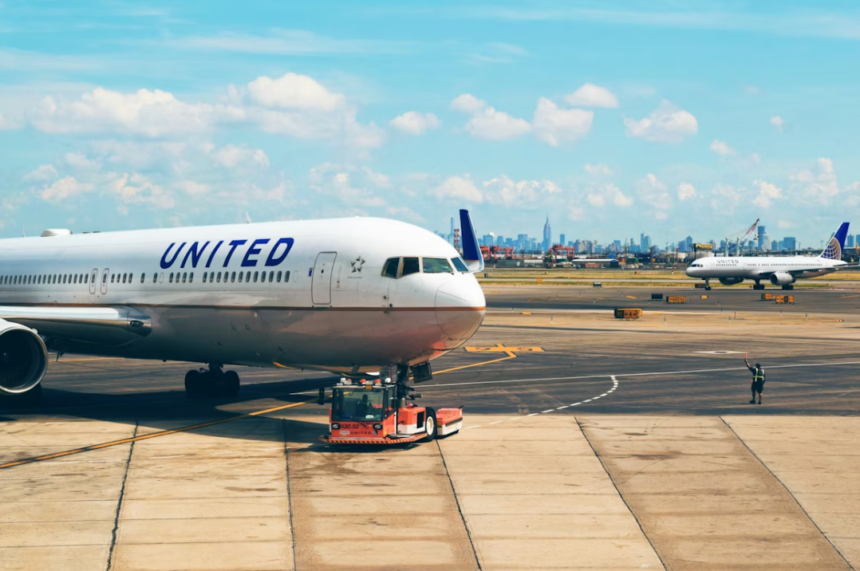 A large white United jetliner sitting at the airport