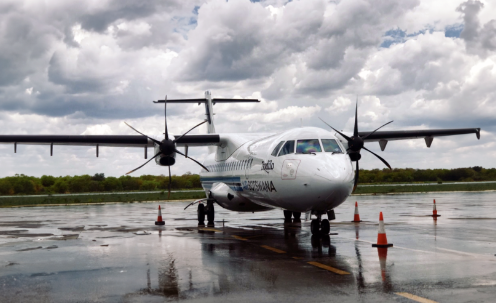 A small white plane with propellers sitting at an airport
